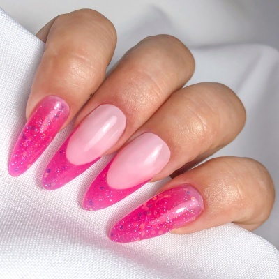 Unhas artificiais rosa com glitter segurando tecido branco