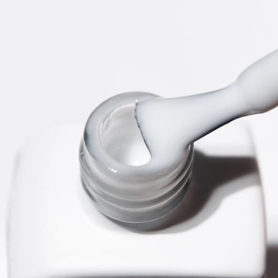 Frasco aberto com pincel e líquido branco