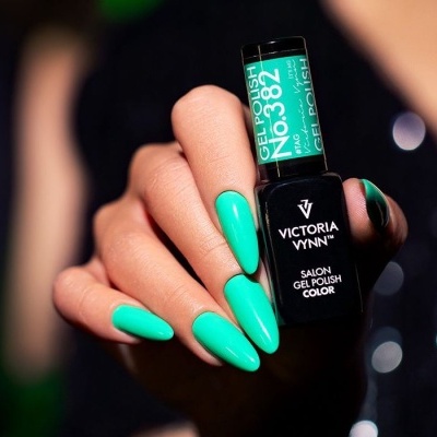 Mão segurando frasco de verniz gel verde turquesa da marca Victoria Vynn