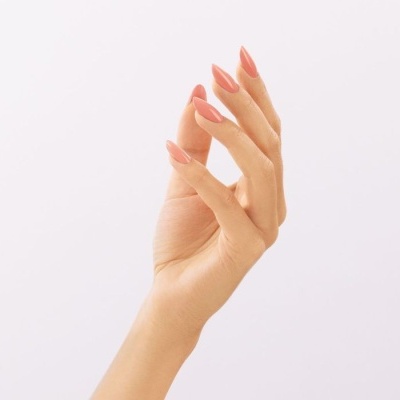 Mão com unhas pintadas rosa coral