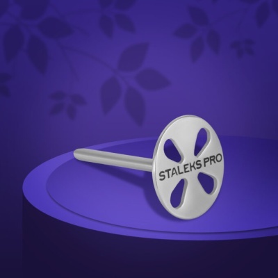 Ferramenta metálica Staleks Pro sobre superfície roxa com fundo de folhas