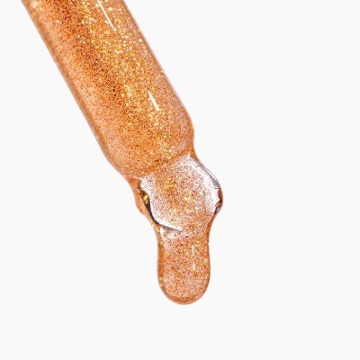 Pipeta com líquido viscoso laranja e partículas douradas