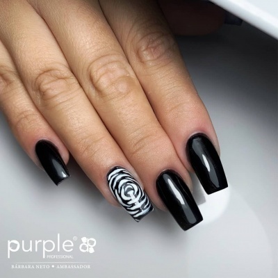 Unhas postiças pretas e brancas com padrão ondulado, sobre fundo branco.