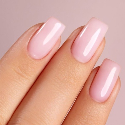 Mão com unhas postiças rosa claro e brilhantes