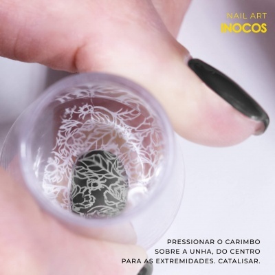 Unha preta com padrão branco e carimbo translúcido com padrão floral, texto 'NAIL ART INOCOS' e instruções em português