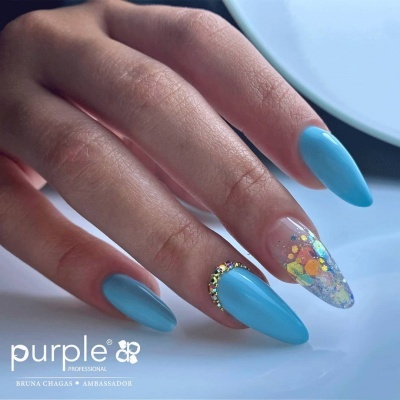 Unhas compridas com esmalte azul e decoração translúcida colorida com glitter