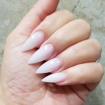 Unhas artificiais pontiagudas rosa claro brilhosas numa mão