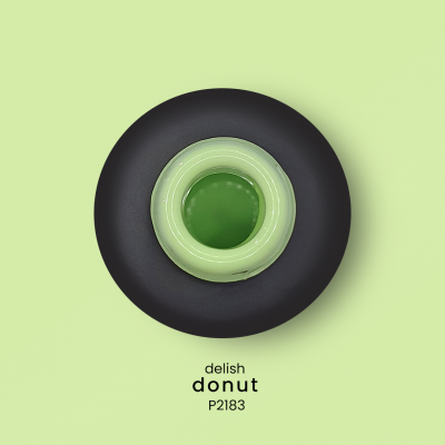 Donut verde no centro de um prato preto com texto 'delish donut P2183' em fundo verde-claro