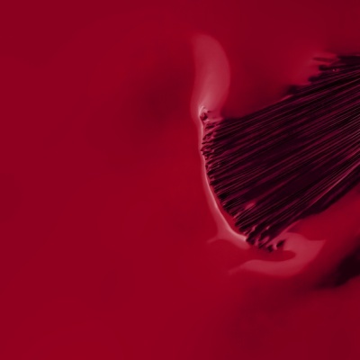Pincel a aplicar verniz vermelho brilhante