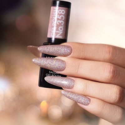 Frasco de verniz gel Victoria Vynn e unhas longas douradas glitter