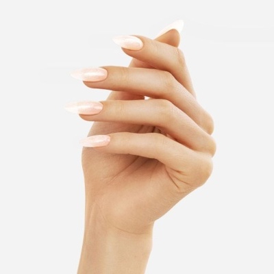 Mão feminina com unhas artificiais cor rosa claro brilhantes.