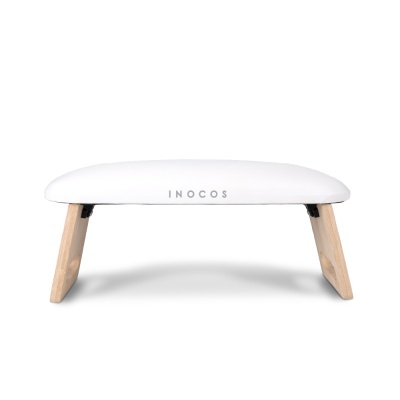 Banco acolchoado branco com pernas de madeira clara e texto INOCOS na frente