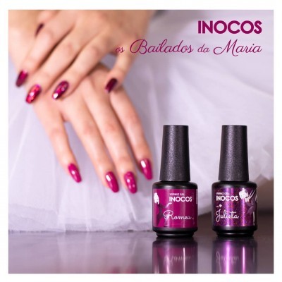 Mãos femininas com unhas vermelhas brilhantes e dois frascos de verniz INOCOS Romeo e Julieta