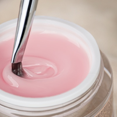 Frasco com gel rosa e pincel metálico dentro