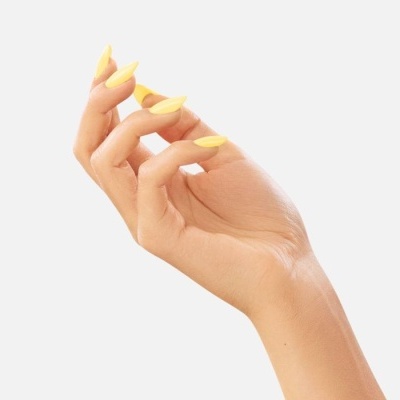 Mão com unhas amarelas sobre fundo branco
