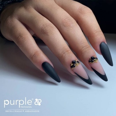 Unhas decoradas em preto mate com pedras pretas e douradas e padrão francês invertido