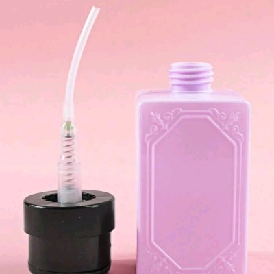 Frasco lilás retangular com tampa preta e tubo plástico