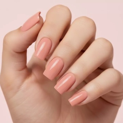 Unhas compridas pintadas de verniz cor de pêssego brilhante