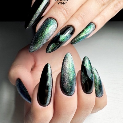 Unhas com design em gel preto e verde metálico brilhante com padrão geométrico.