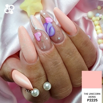Unhas falsas decoradas em rosa, roxo e branco com padrão de corações e estrelas