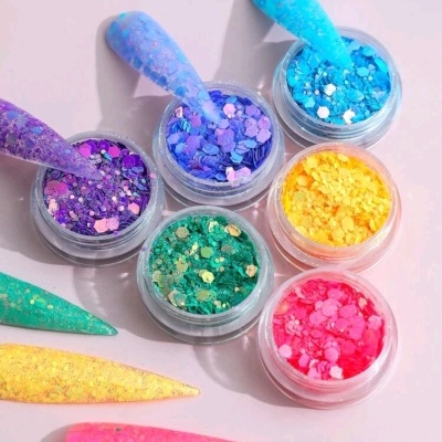 Seis potes de glitter colorido com amostras de unhas postiças correspondentes