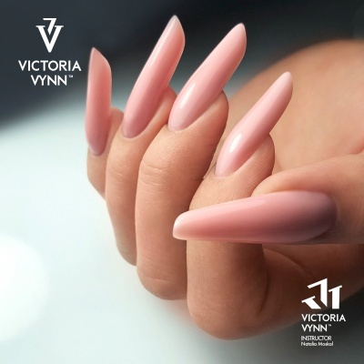 Mão com unhas longas rosa claro e logotipo Victoria Vynn