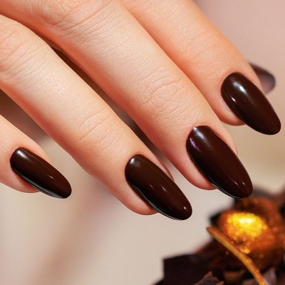 Manicura com verniz castanho escuro brilhante em unhas ovais