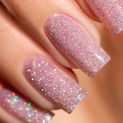 Unhas com verniz cor-de-rosa claro e glitter prateado brilhante
