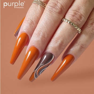 Unhas longas pintadas em laranja e castanho com design, com anéis dourados numa mão