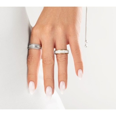 Mão feminina com dois anéis em fundo branco