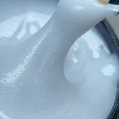 Espátula a levantar espuma branca brilhante de um recipiente preto