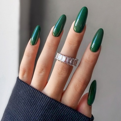 Mão com unhas verdes longas e anel prateado com pedras retangulares