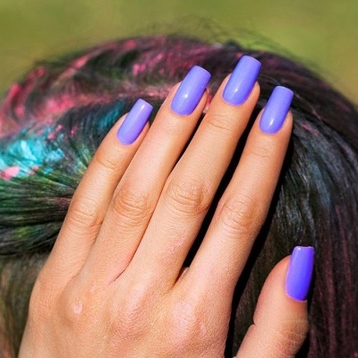 Mão com unhas roxas e cabelo colorido