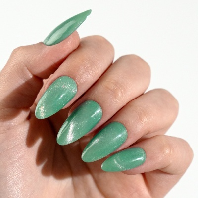 Mão com unhas verdes metálicas brilhantes em fundo branco