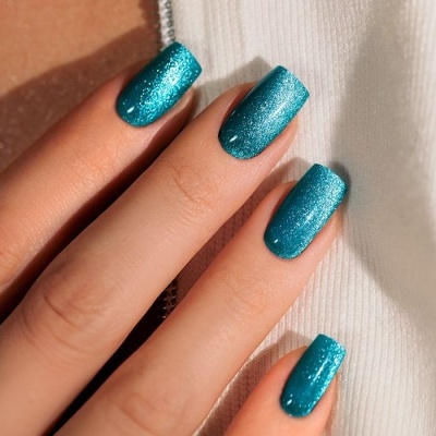 Unhas com esmalte azul turquesa brilhante em mão feminina