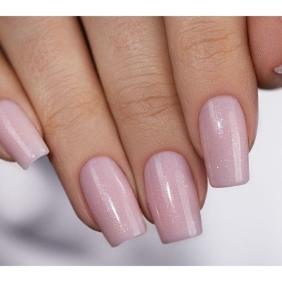Unhas pintadas de rosa claro brilhante com efeito cintilante