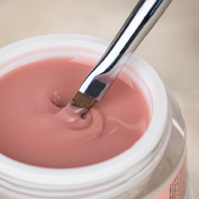 Frasco de verniz rosa claro com pincel para unhas