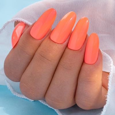 Mão feminina com unhas laranja neon