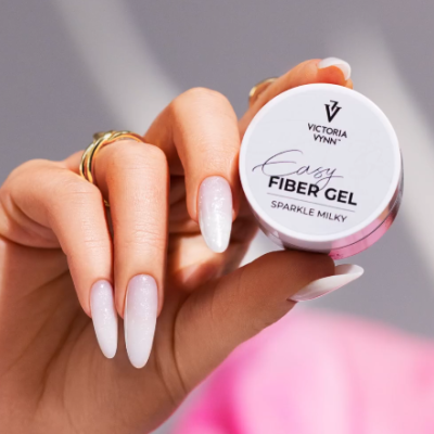 Frasco pequeno redondo de gel para unhas VICTORIA VYNN EASY FIBER GEL SPARKLE MILKY na mão com unhas brancas brilhantes