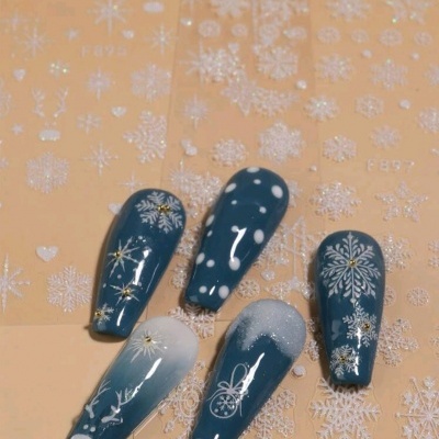 Unhas postiças azuis com desenhos de flocos de neve e motivos natalícios