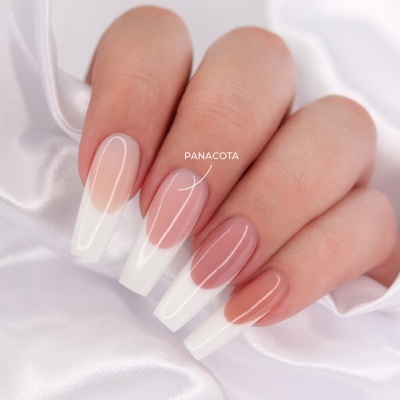 Mão com unhas artificiais alongadas padrão francês transparente e branco com etiqueta 'PANACOTA' sobre tecido branco acetinado