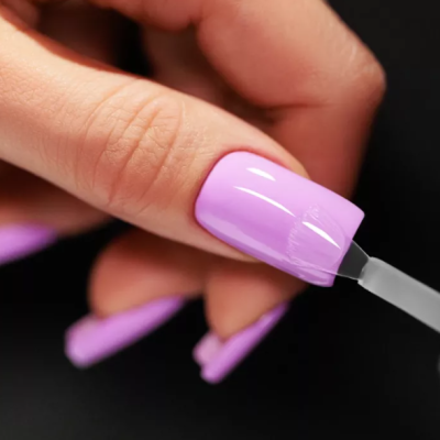 Unha a ser pintada com verniz lilás brilhante