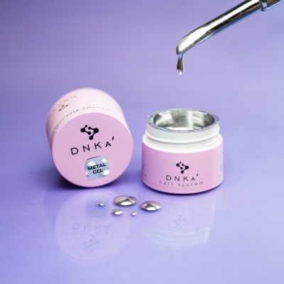 Frasco rosa claro com creme metálico aberto e conta-gotas numa superfície lilás