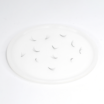 Cílios postiços pretos curvados num prato branco