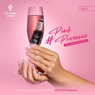 Mão com unhas pintadas de rosa clara segurando taça com verniz de gel Victoria Vynn dentro e fundo rosa.