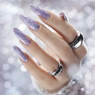 Mão com unhas glitter lilás e anéis prateados
