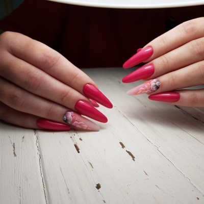 Unhas compridas com verniz rosa e detalhes florais em duas unhas