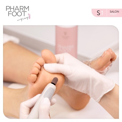 Tratamento de pés com ferramenta elétrica e luvas brancas, frasco rosado ao fundo