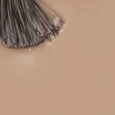 Pincel de maquilhagem com cerdas pretas e empunhadura metálica sobre fundo bege claro