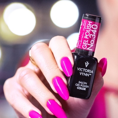 Mão com unhas pintadas de rosa magenta segurando verniz em gel Victoria Vynn Nº340